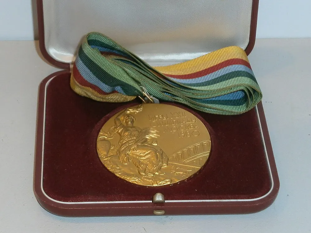 Olympic gold medal on a ribbon, souvenir-worthy like a CS2 souvenir package