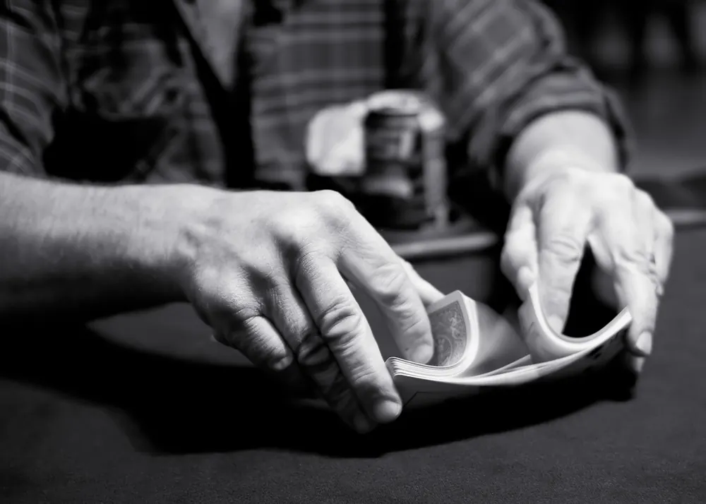 Hands riffle shuffling a deck of cards before making CS2 betting predictions