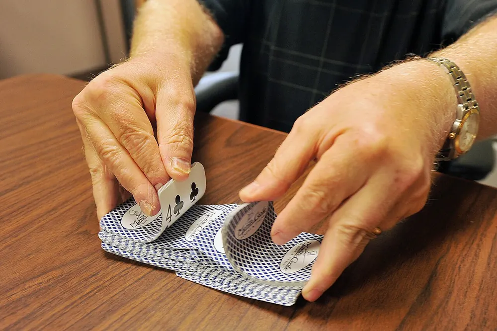 Hands shuffling a deck of playing cards