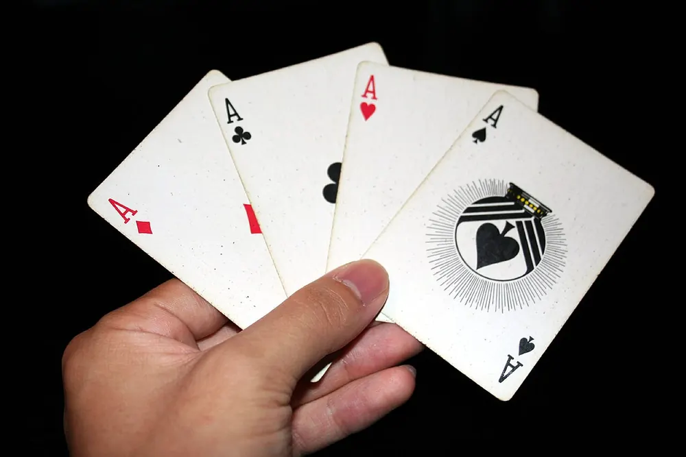 Hand holding the four aces, a crash gambling strategy dream