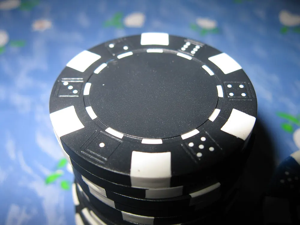 Close-up of a single black and white poker chip, one bet on a CS2 match