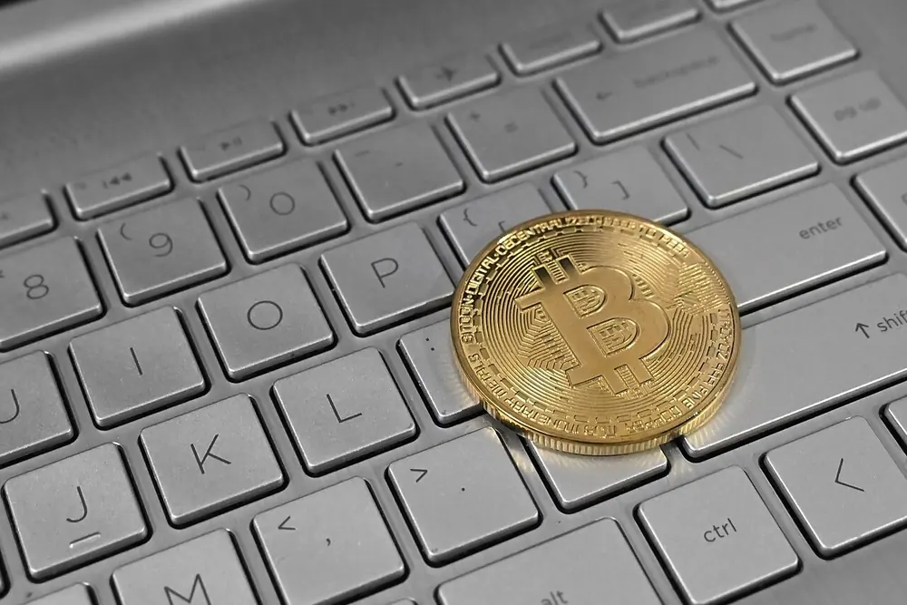 Gold bitcoin coin on a laptop keyboard