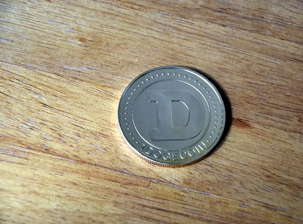 Silver crypto coin resting on a wooden surface