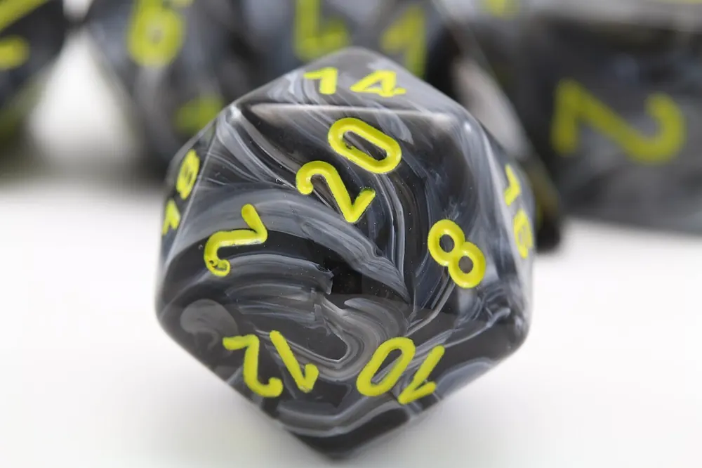 Close-up of a d20 die with yellow numbers
