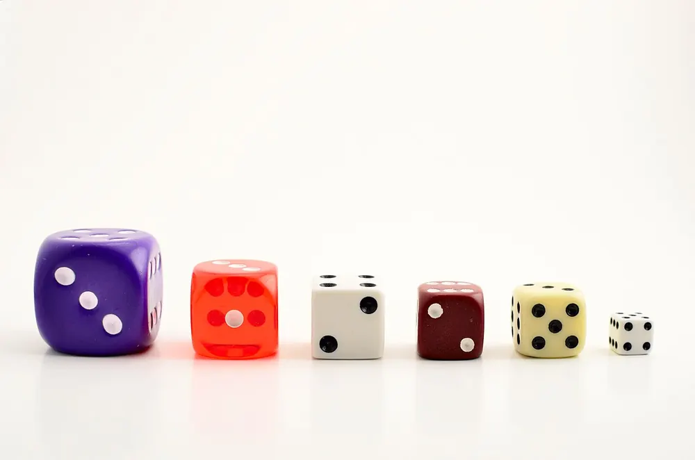 Row of different colored dice on a white table