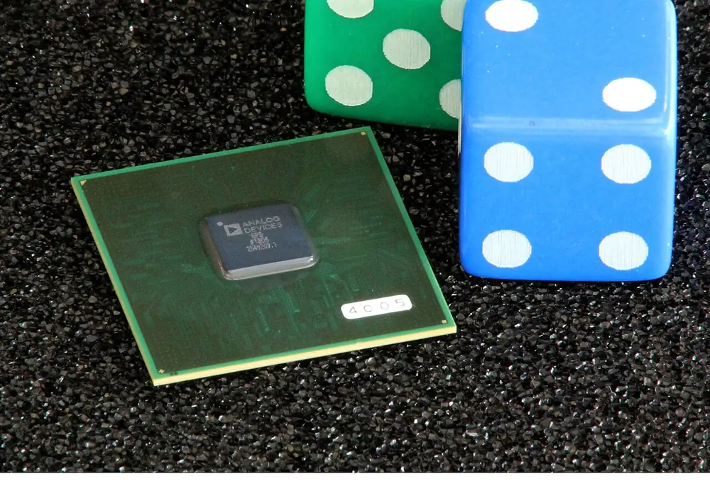 Blue die beside a computer chip