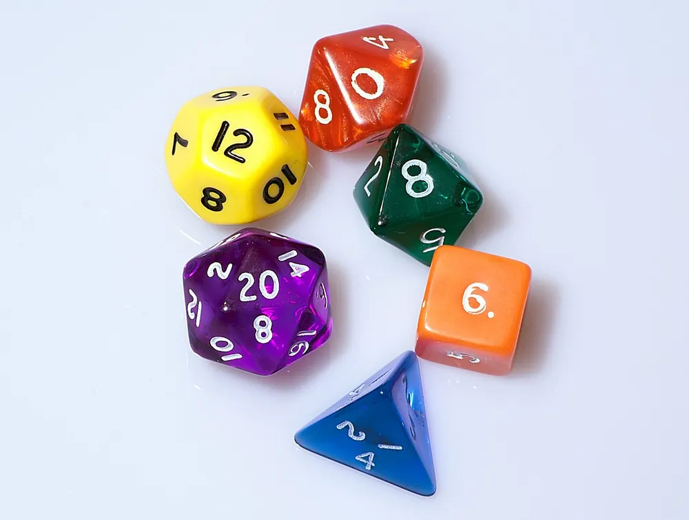 Colorful polyhedral dice on a white background, the CSGOEmpire KYC roll of the dice