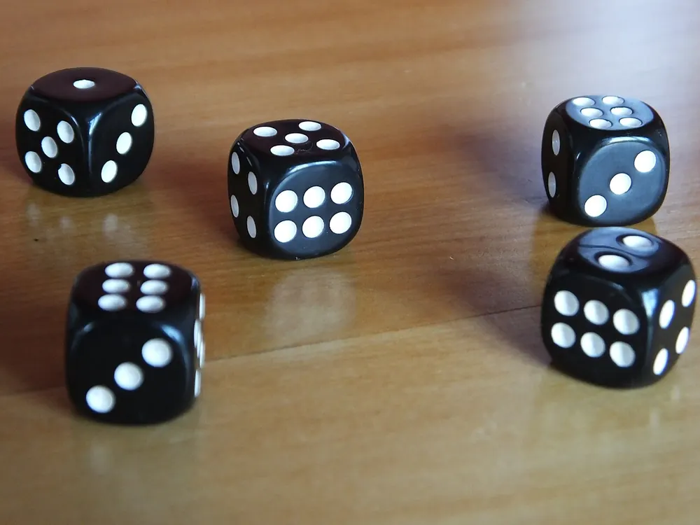 Black dice scattered on a wooden table