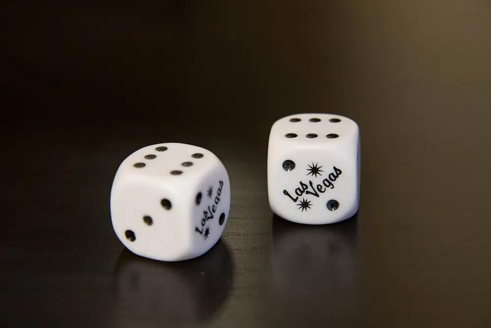 Pair of white dice on a dark wood table