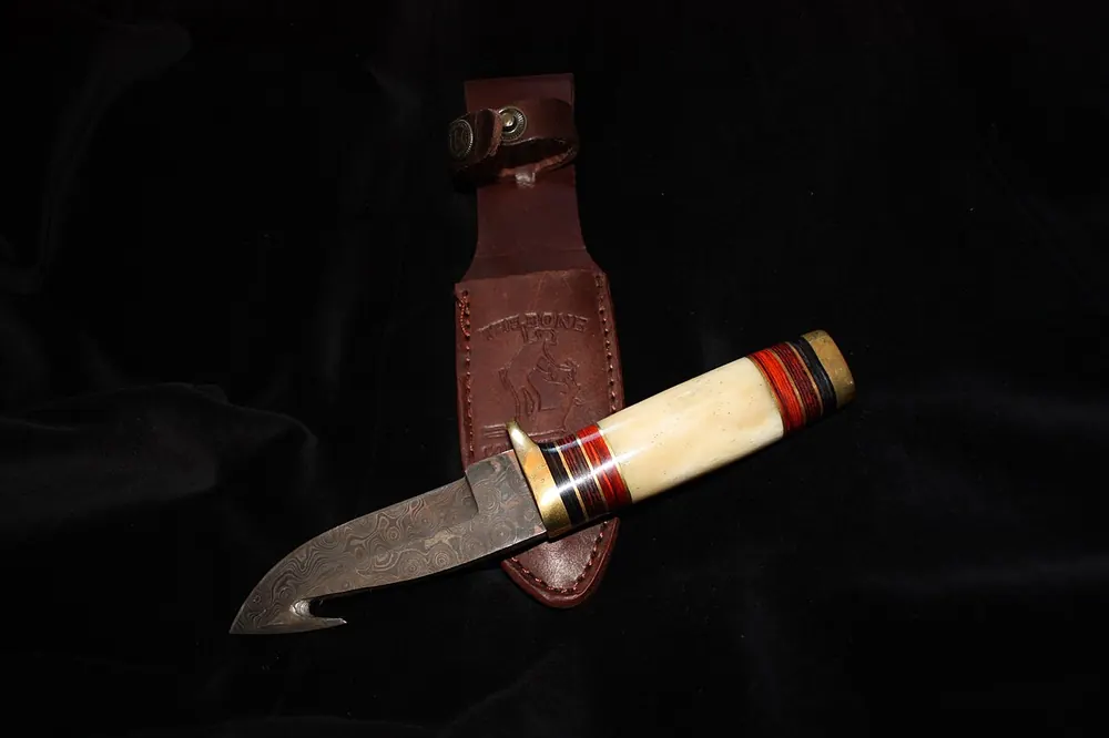 Damascus steel hunting knife with a patterned blade, top-tier CS2 knife vibes