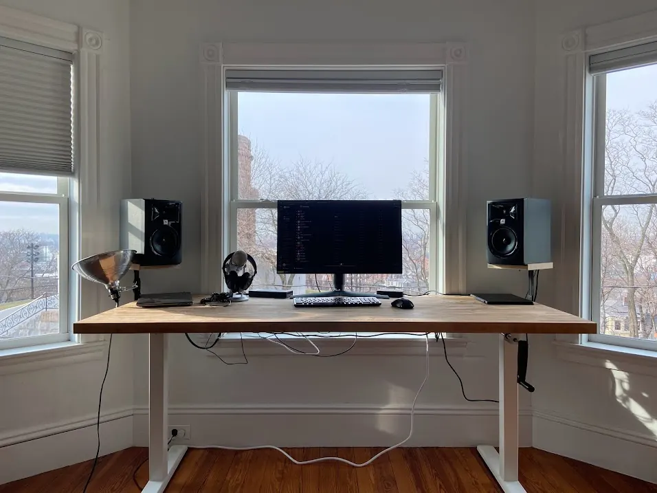 Standing desk with a computer and monitor in a bright room