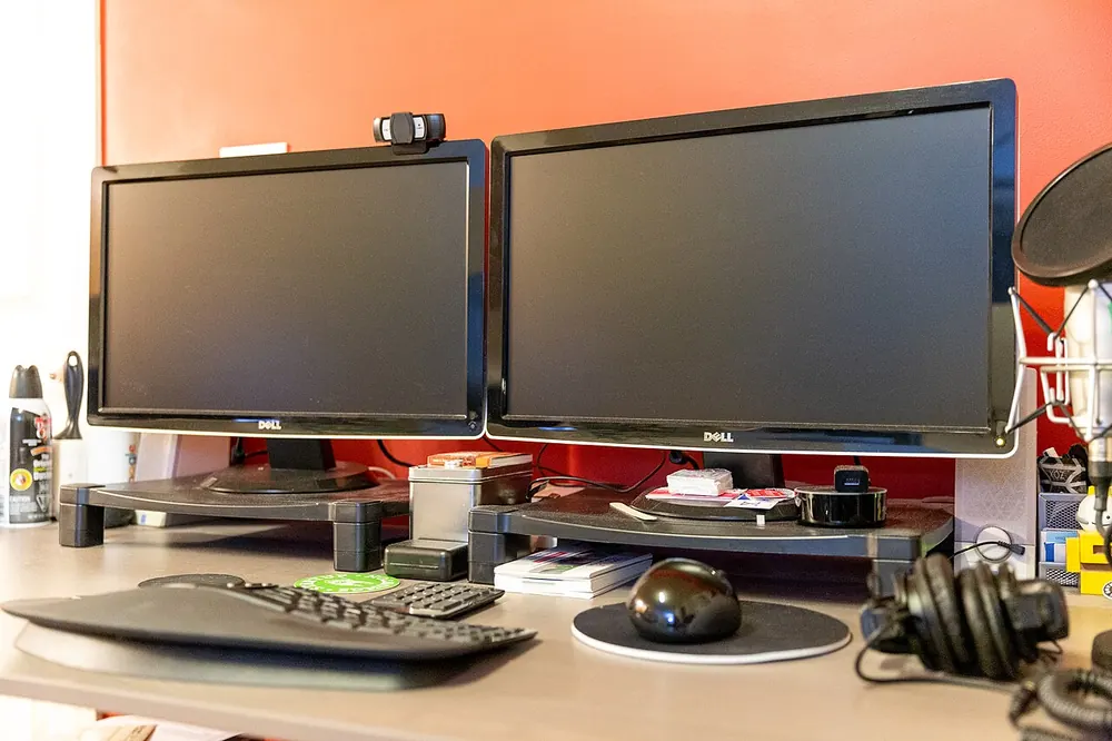 Desk with dual monitors, a keyboard and a mouse, where you can track your CS2 gambling
